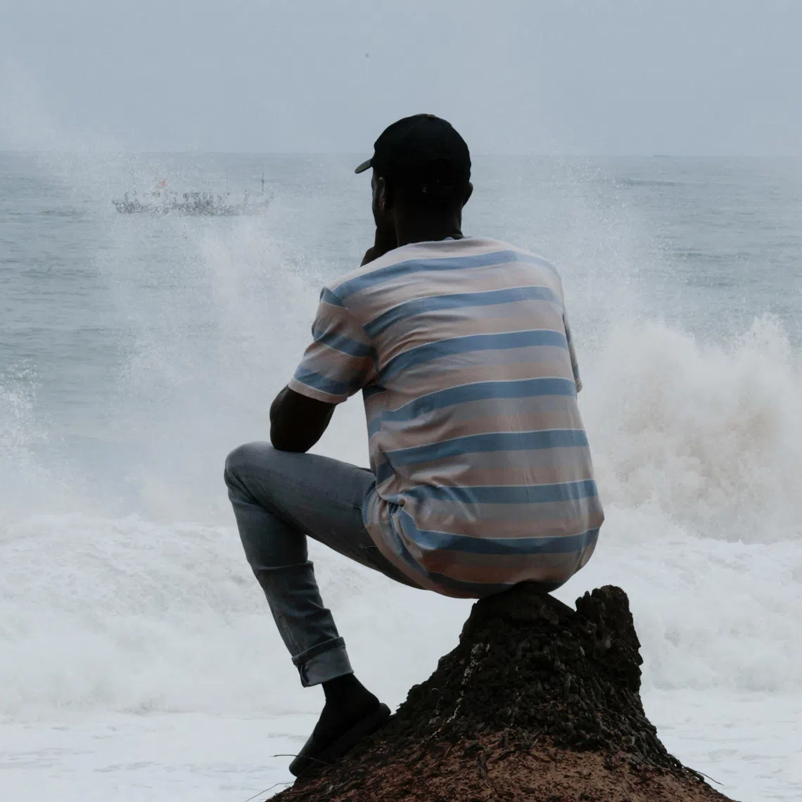 Latifou, a gay Togolese man who says he was forced onto a U.S. deportation flight to a third country before relocating to Ivory Coast, sits on a beach overlooking the Atlantic Ocean in Abidjan, Ivory Coast, September 21, 2026. REUTERS/Luc Gnago