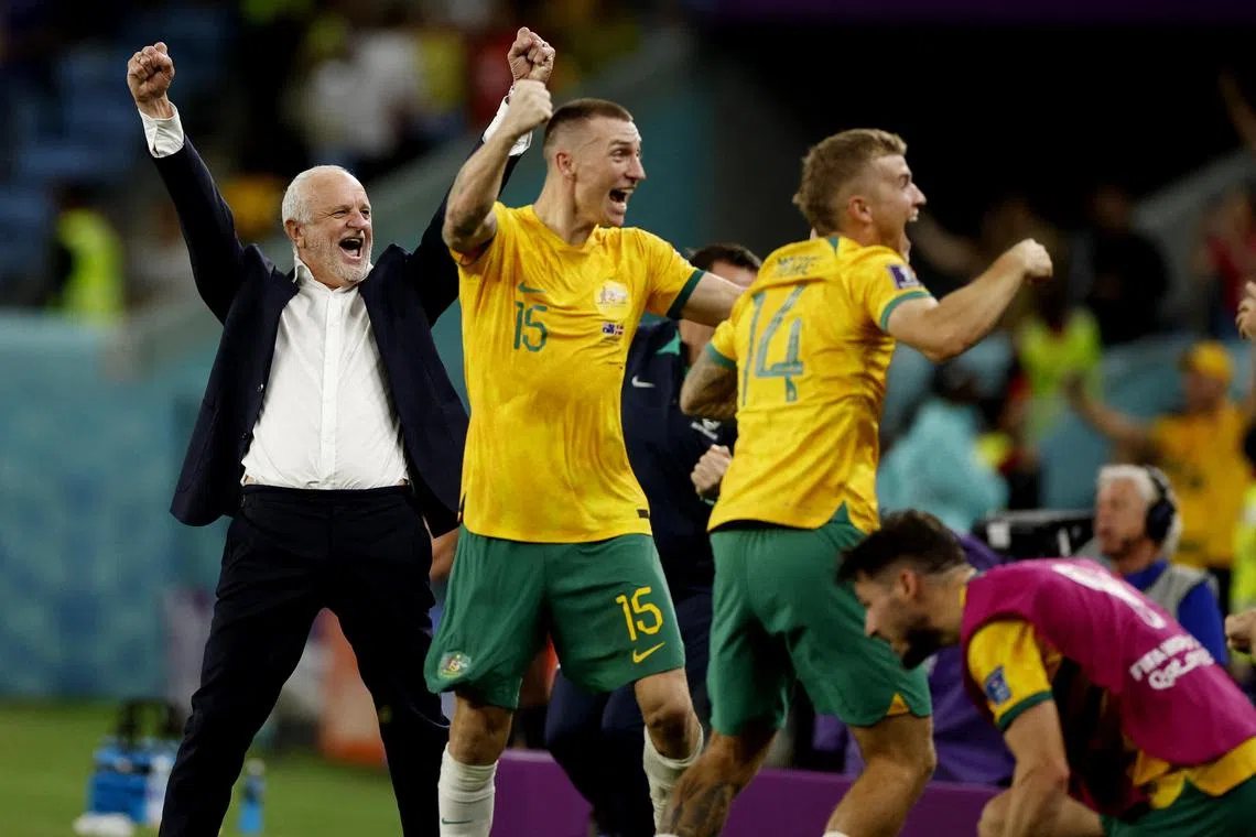 Australia coach Graham Arnold celebrating with his players after beating Denmark and qualifying for the round of 16.