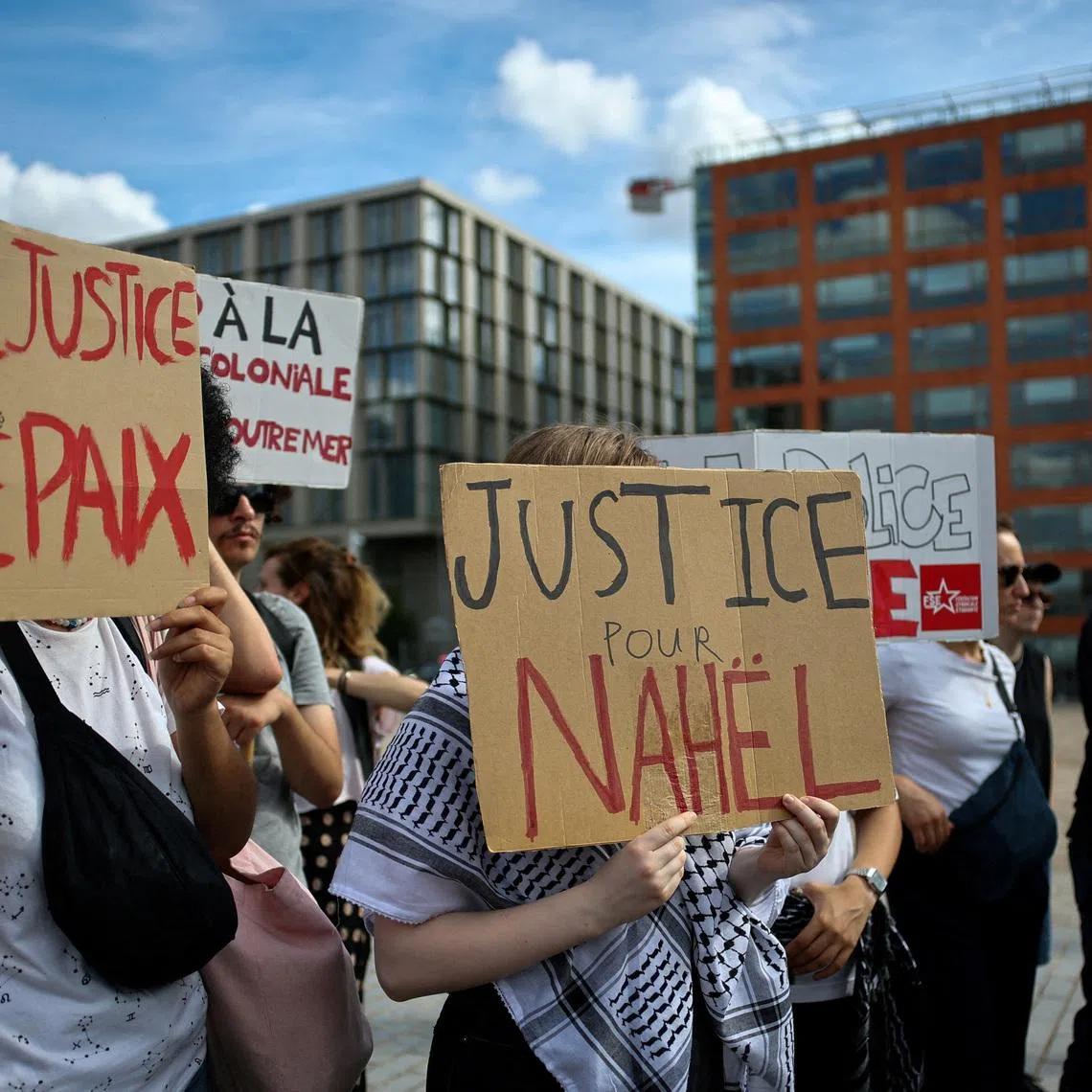FILE PHOTO: People hold placards during a demonstration to demand justice two years after the death of Nahel, a 17-year-old teenager killed by a French police officer during a traffic stop, in Nanterre, near Paris, France, June 27, 2025. REUTERS/Gonzalo Fuentes/File Photo