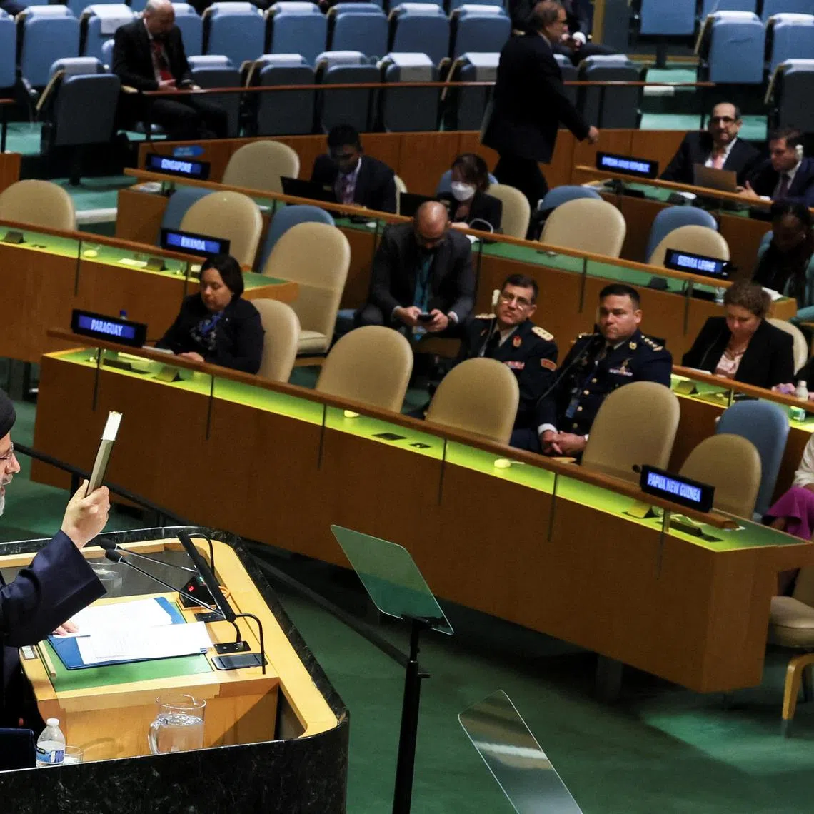 Iran's President Ebrahim Raisi holds up the Quran as he addresses the 78th Session of the UN General Assembly.
