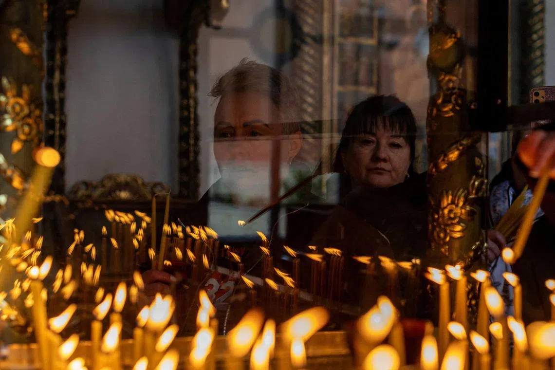 A Ukrainian living in Turkey lights candles during a memorial service for the victims of Russia's attack on Ukraine, on the fourth anniversary of the full-scale Russian invasion of Ukraine, at the Patriarchal Church of St. George in Istanbul, Turkey, on Feb 24, 2026. 