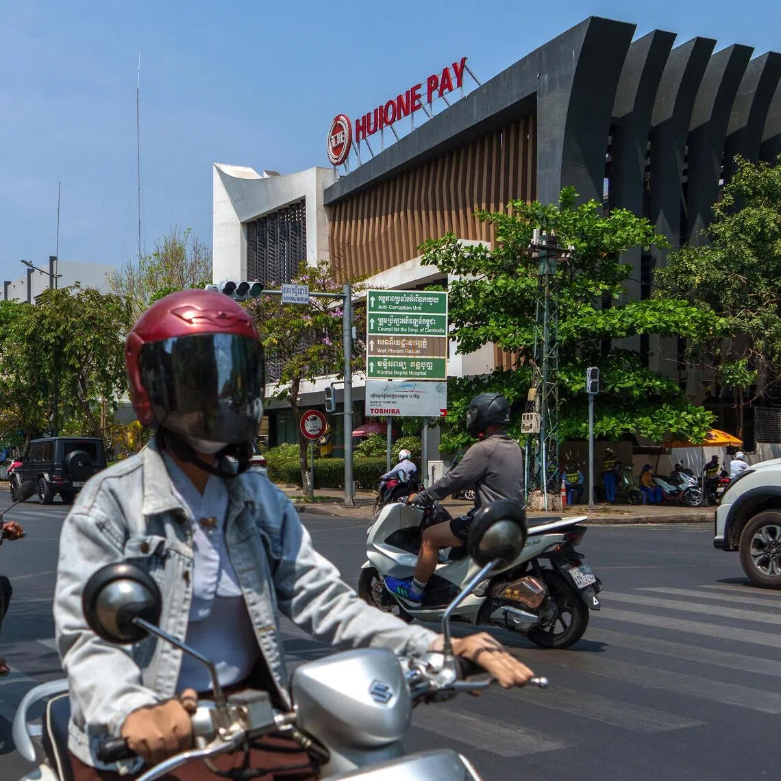Motorists pass by the Huione Pay headquarters at a busy intersection in Phnom Penh, Cambodia.