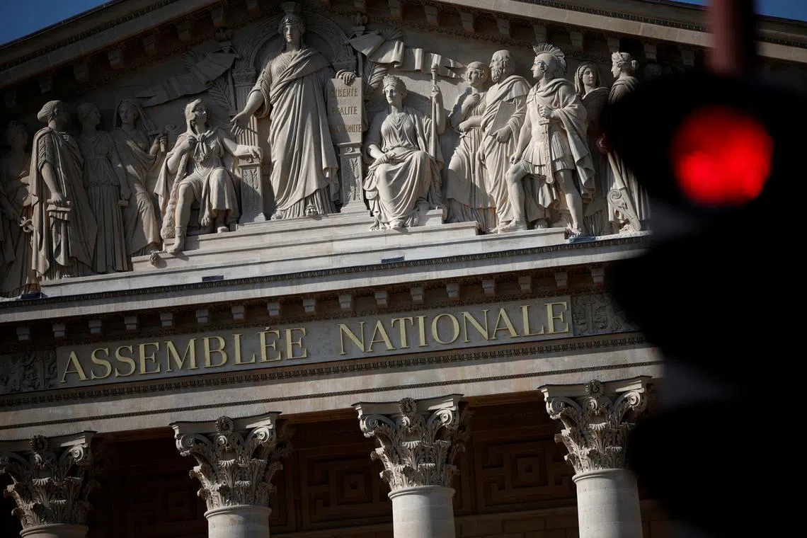 FILE PHOTO: A traffic light shines red near the National Assembly in Paris, ahead of early legislative elections in France, June 13, 2024. REUTERS/Stephane Mahe/File Photo