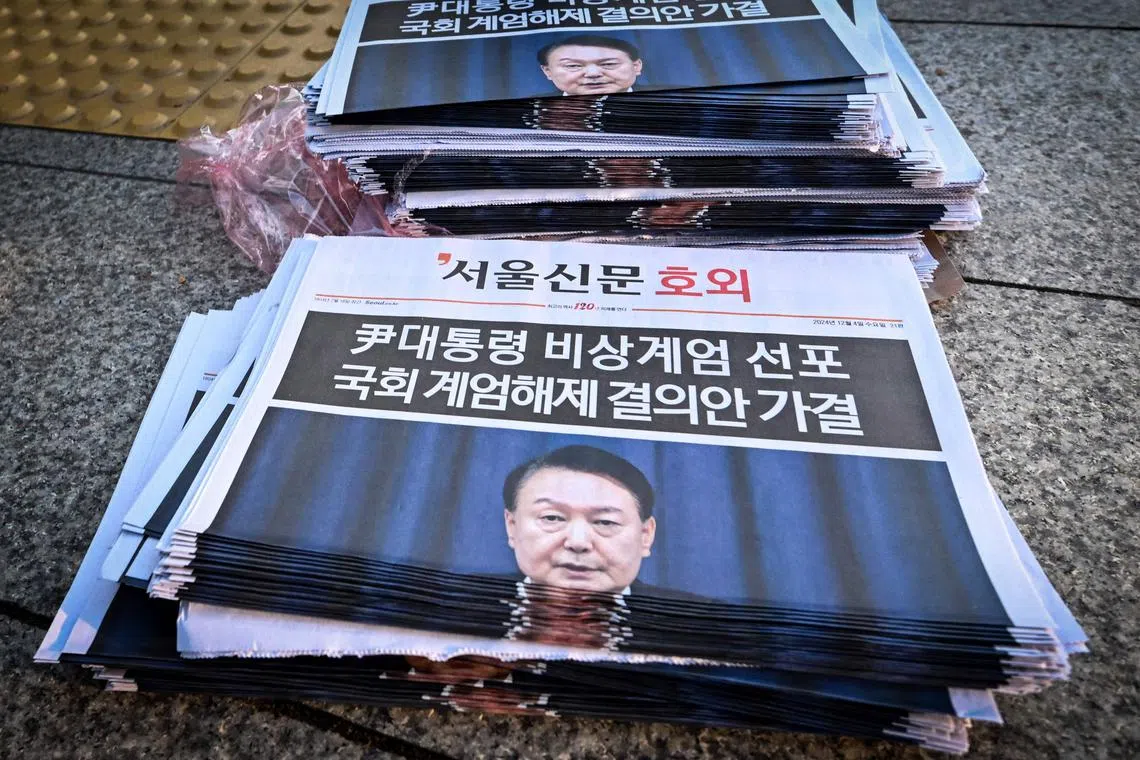 Extra edition newspapers are displayed at a subway gate in downtown Seoul on December 4, 2024, after martial law was lifted. South Korean President Yoon Suk Yeol abandoned a short-lived attempt at martial law on December 4, after lawmakers defied security forces to vote against his declaration and thousands of protesters took to the streets. (Photo by Jung Yeon-je / AFP)