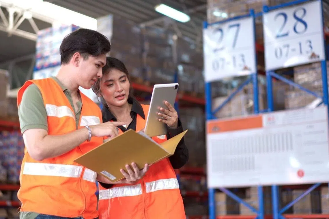 Shopee logistics team in a warehouse looking at delivery schedules 