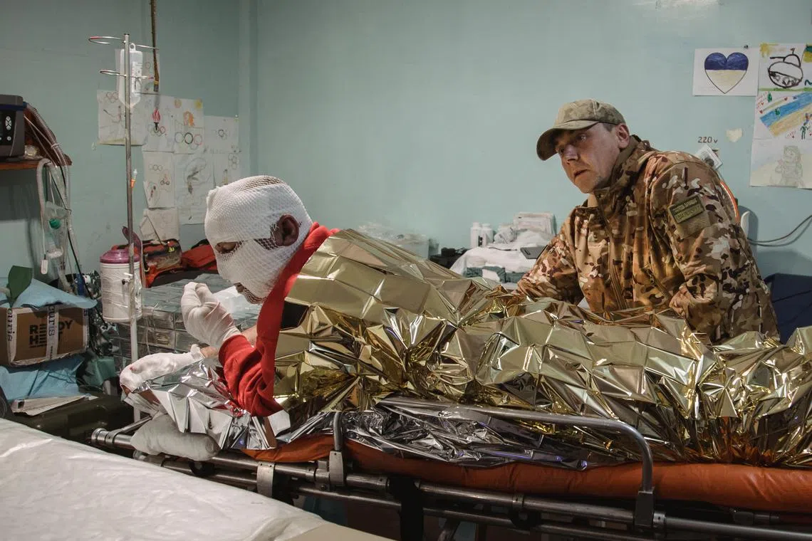 Military doctor treating an injured men at a stabilisation point near the frontline in Donetsk region, eastern Ukraine on October 16, 2023 (issued 17 October 2023). Russian troops entered Ukraine in February 2022 starting a conflict that has provoked destruction and a humanitarian crisis.  