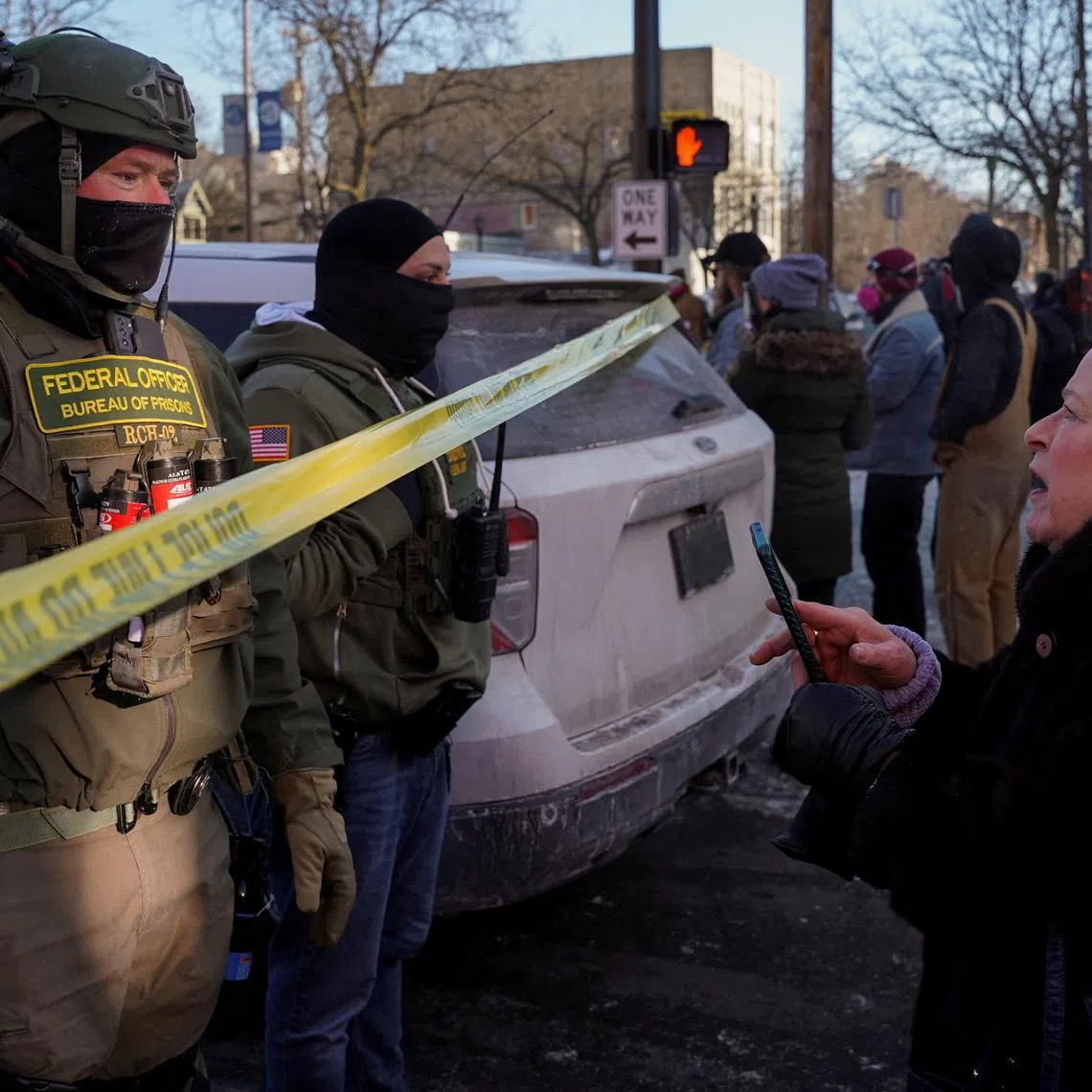 FILE PHOTO: Federal agents stand behind police tape as people gather near the site where a man identified as Alex Pretti was fatally shot by federal agents trying to detain him, in Minneapolis, Minnesota, U.S., January 24, 2026. REUTERS/Seth Herald/File Photo