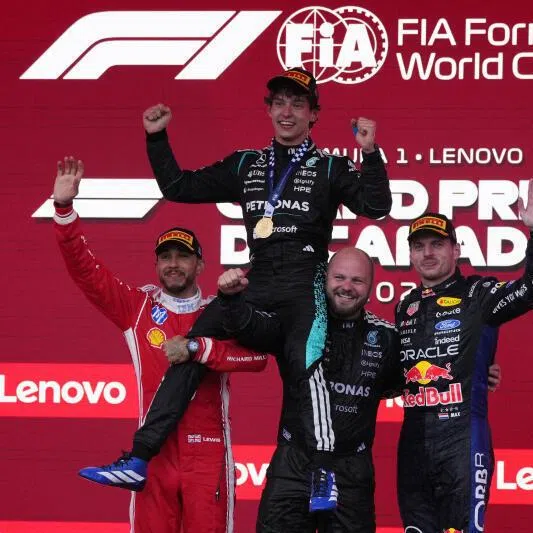 Mercedes' Andrea Kimi Antonelli celebrates on the podium after winning the Canadian Grand Prix alongside second placed Ferrari's Lewis Hamilton and third placed Red Bull's Max Verstappen.
