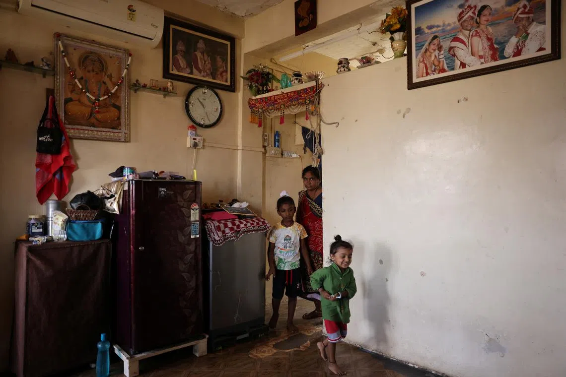 Rahul Makwana's family walking into their home before moving from the four to the first floor following a notice about the building pillars weakening on March 30, 2023.    