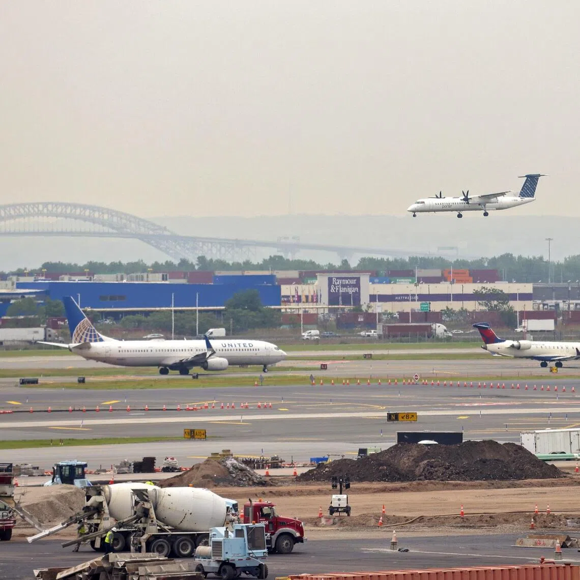 epa12103674 A plane lands at Newark Liberty International Airport, which has been experiencing a shortage of air traffic controllers, as other planes wait in a queue on the tarmac in Newark, New Jersey, USA, 15 May 2025. Newark has had three communications blackouts in more than a week, rendering the control tower unable to track or communicate with planes for up to 90 seconds.  EPA-EFE/SARAH YENESEL