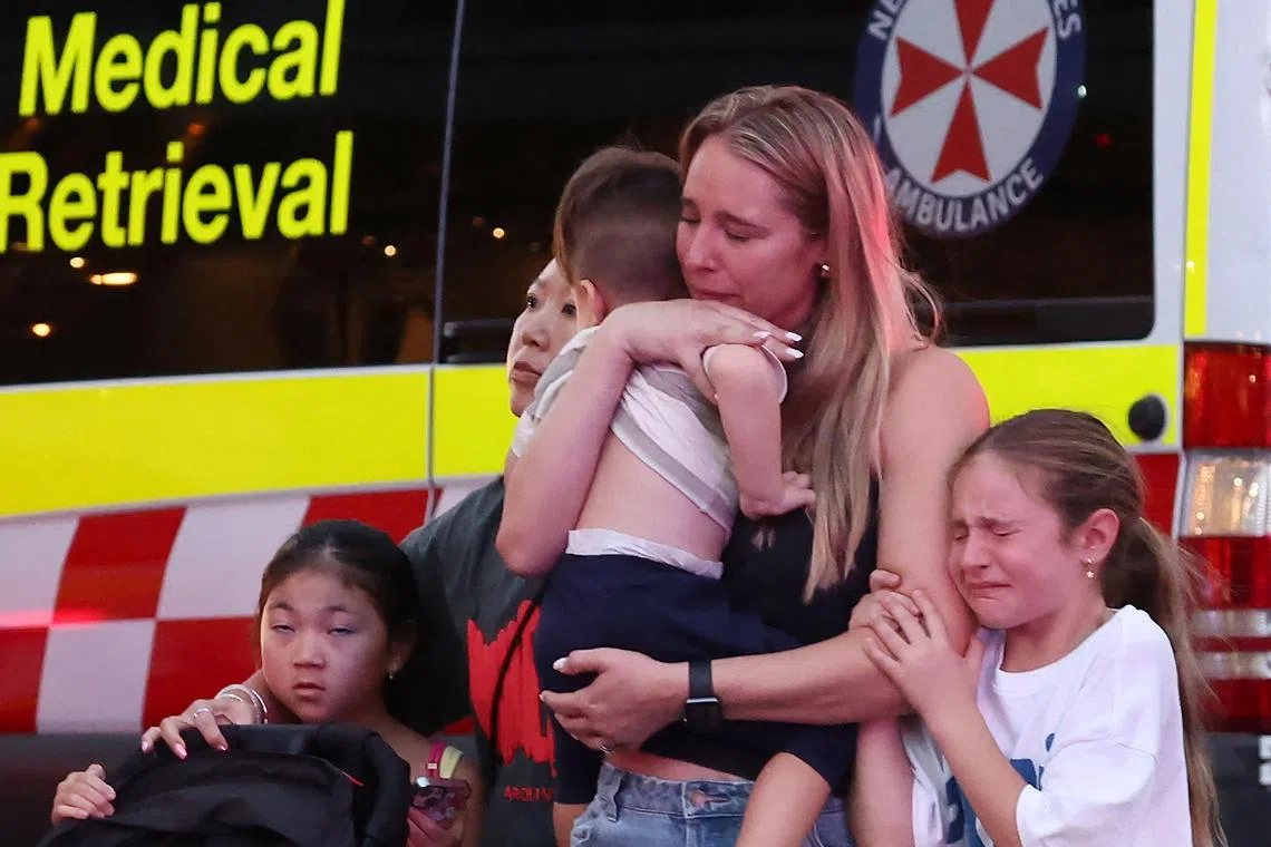 A family leaves the Westfield Bondi Junction shopping mall after a stabbing incident in Sydney on April 13.