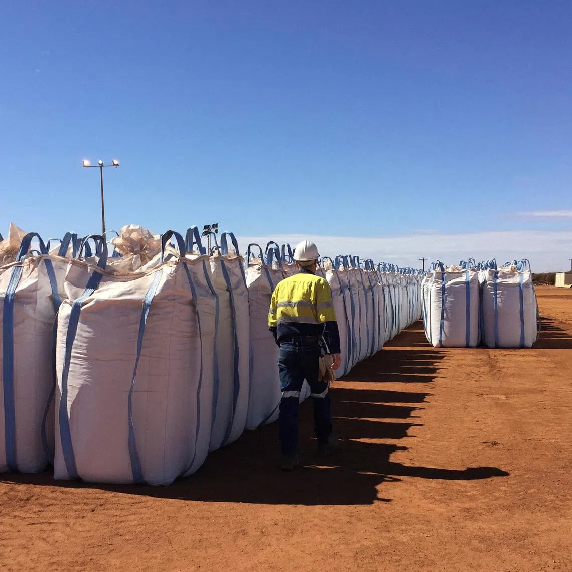 A Lynas Corp worker walks past sacks of rare earth concentrate waiting to be shipped to Malaysia, at Mount Weld, northeast of Perth, Australia August 23, 2019. REUTERS/Melanie Burton