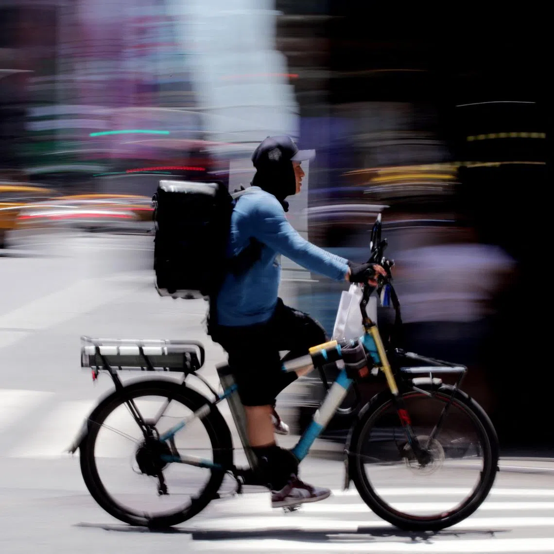 A delivery worker rides a bike through Times Square in New York City on June 24, 2025. A potentially life-threatening heat wave enveloped the eastern third of the United States on June 23 impacting nearly 160 million people, with temperatures this week expected to reach 102 degrees Fahrenheit (39 degrees Celsius) in the New York metropolitan area. Dangerously high temperatures are forecast through midweek in Washington, Baltimore, Philadelphia, New York City and Boston. (Photo by Leonardo Munoz / AFP)