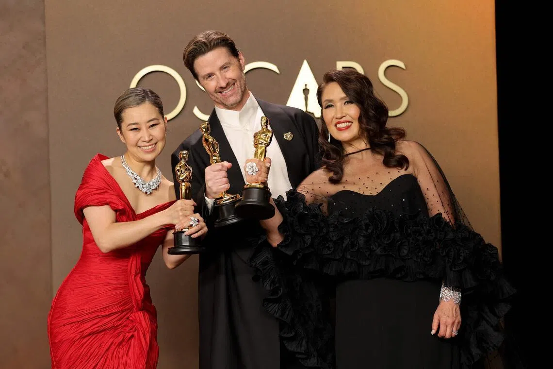 (From left) Maggie Kang, Chris Appelhans, and Michelle Wong, winners of the Best Animated Feature Film Award for KPop Demon Hunters, pose in the press room during the 98th Oscars at Dolby Theatre on March 15.