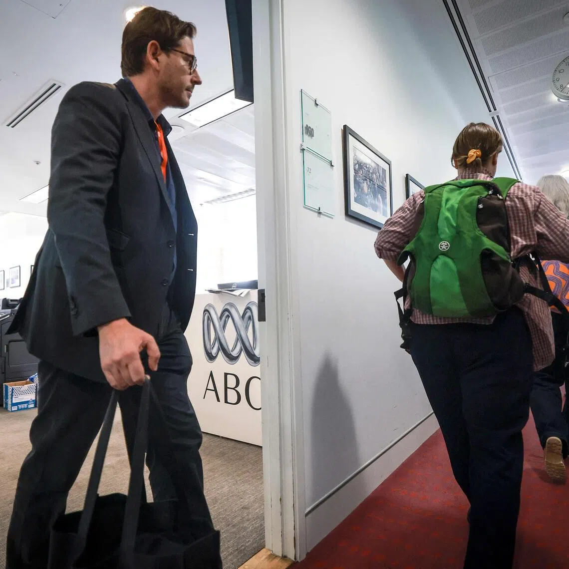 Staff of Australia’s national broadcaster ABC walk out of their office in the press gallery of Parliament House as they begin a national strike action in Canberra on March 25.