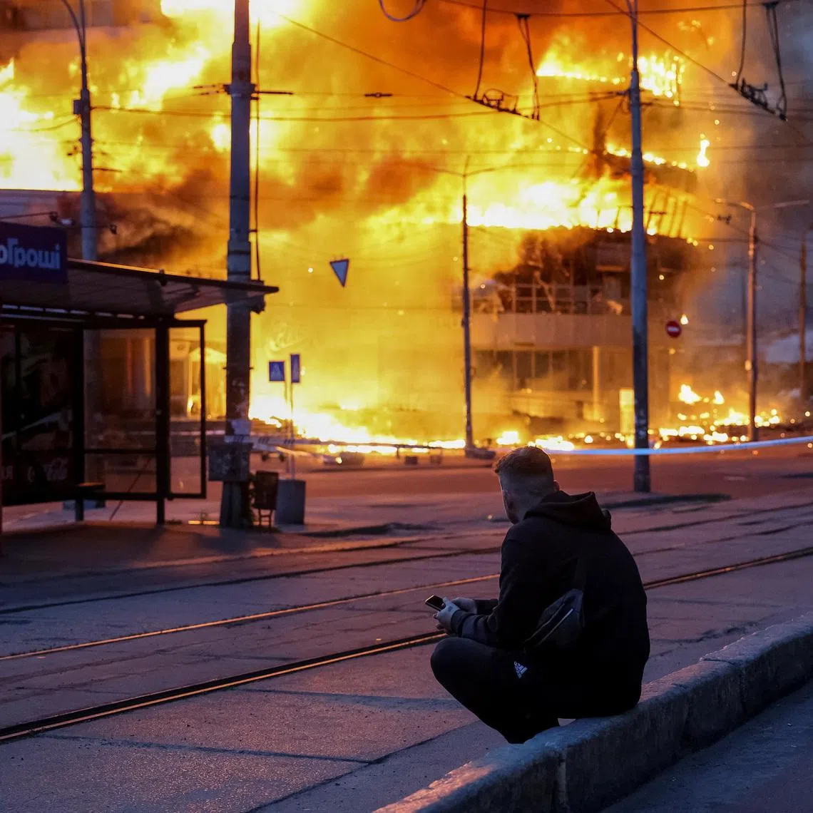 A resident sits at a site of a Russian missile and drone strike, amid Russia's attack on Ukraine, in Kyiv, Ukraine May 24, 2026. REUTERS/Stringer