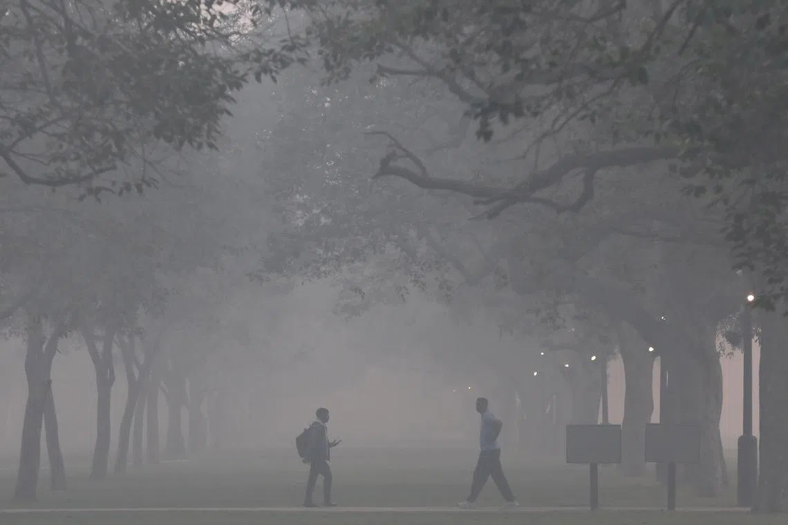People walk amid thick smog  in New Delhi, on Nov 3, 2022.