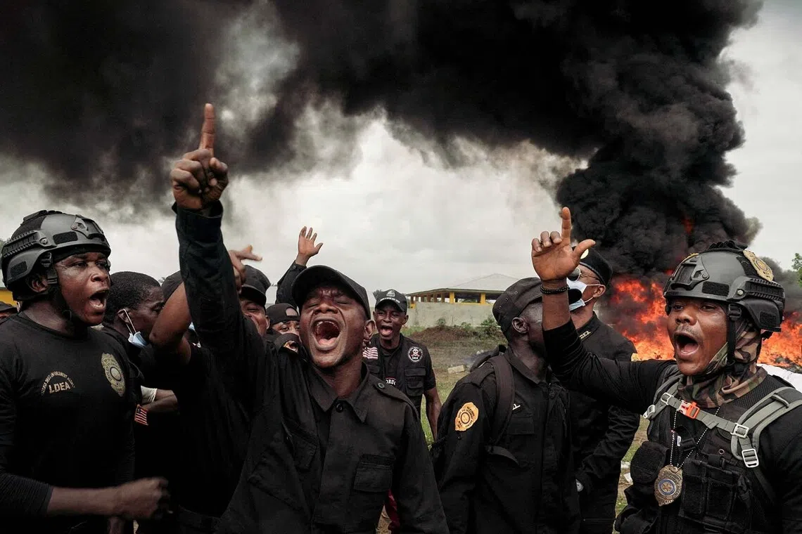 Liberian Drug Enforcement Agency officers celebrate after burning approximately 4.2 metric tons of cocaine during a destruction operation in Monrovia, Liberia, July 30, 2026. REUTERS/Carielle Doe REFILE - QUALITY REPEAT TPX IMAGES OF THE DAY