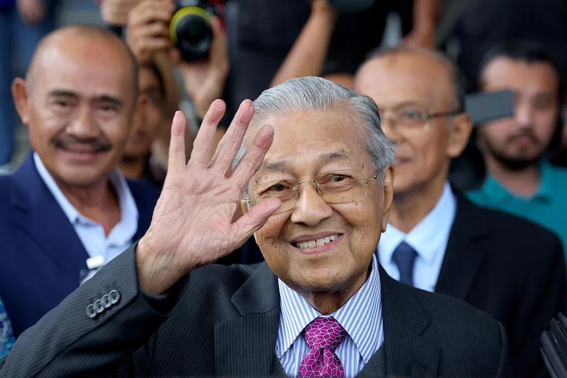 Former Malaysian prime minister Mahathir Mohamad waves upon leaving the Kuala Lumpur High Court on Aug 26.
