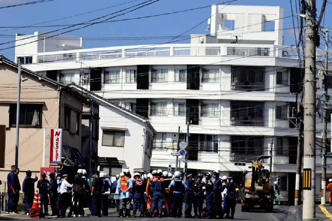 Police officers stand around a sinkhole that developed in Hiroshima City on Sept 26, 2024.