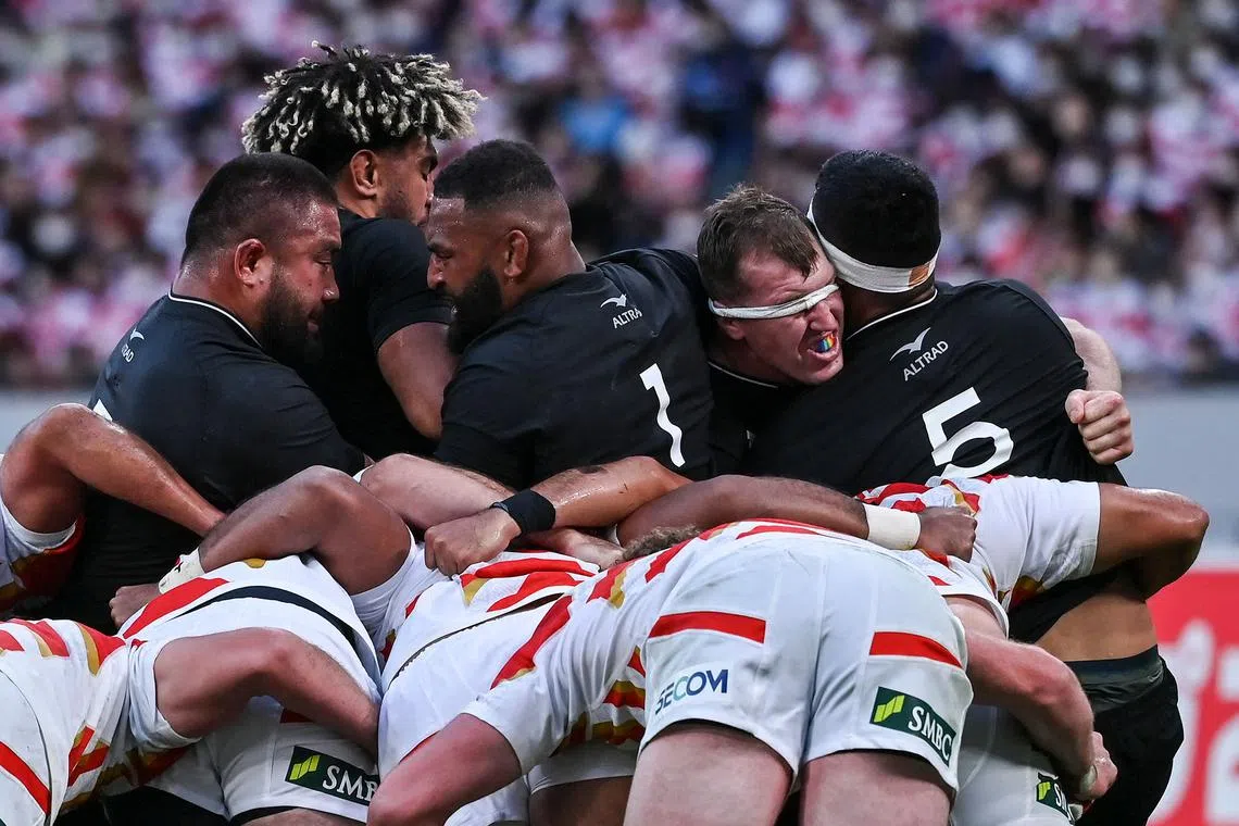 New Zealand (in black) being pushed back by Japan during a scrum at the rugby union Test match at the National Stadium in Tokyo on Oct 29. New Zealand Rugby has said it would continue to trial a scrum rule which bans teams from pushing a scrum more than 1.5 metres.