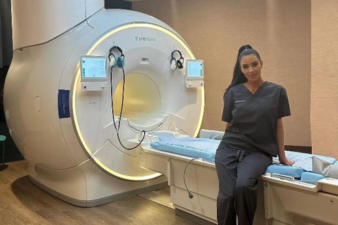 American reality television star Kim Kardashian posing with Prenuvo's magnetic resonance imaging machine.