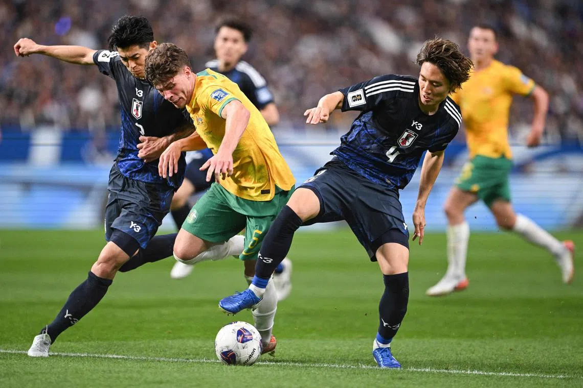 From left: Japan's Shogo Taniguchi, Australia's Jordan Bos and Ko Itakura of Japan compete for the ball during their World Cup qualifier.