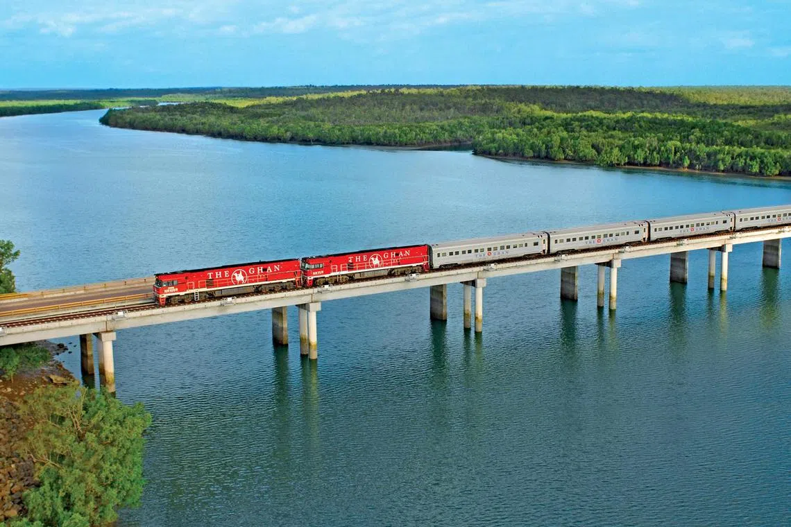 The Ghan, a legendary passenger train operated by the Great Southern Rail company, crossing the Elizabeth River south of Darwin. The railway travels between Adelaide in southern Australia and Darwin in the north in 54 hours.