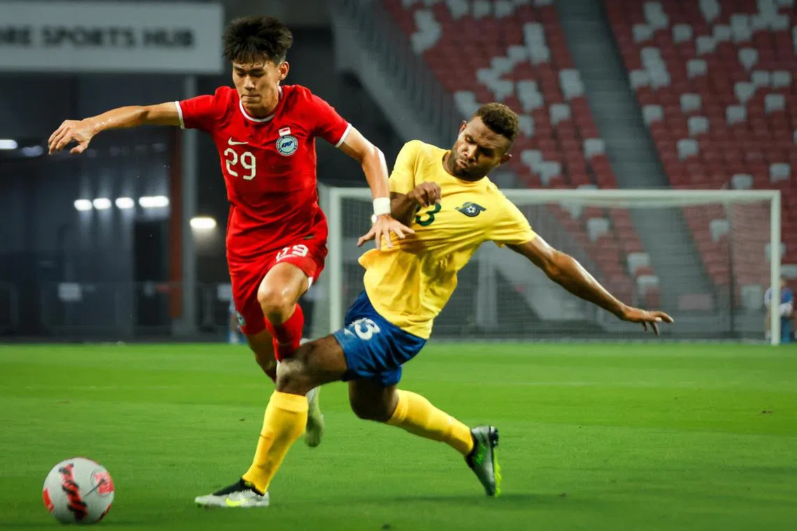 Singapore’s Daniel Goh (in red) fighting for the ball with Solomon Islands’ David Supra in a 1-1 draw at the National Stadium, June 18, 2023.