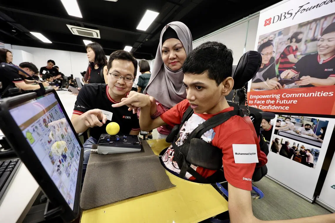 Mr Muhammed Sayfullah, 20, (right) attends a workshop by DBS Foundation and SG Enable on digital and financial literacy, accompanied by his mother Siti Fadillah Mohamed Noor, 45 (middle).