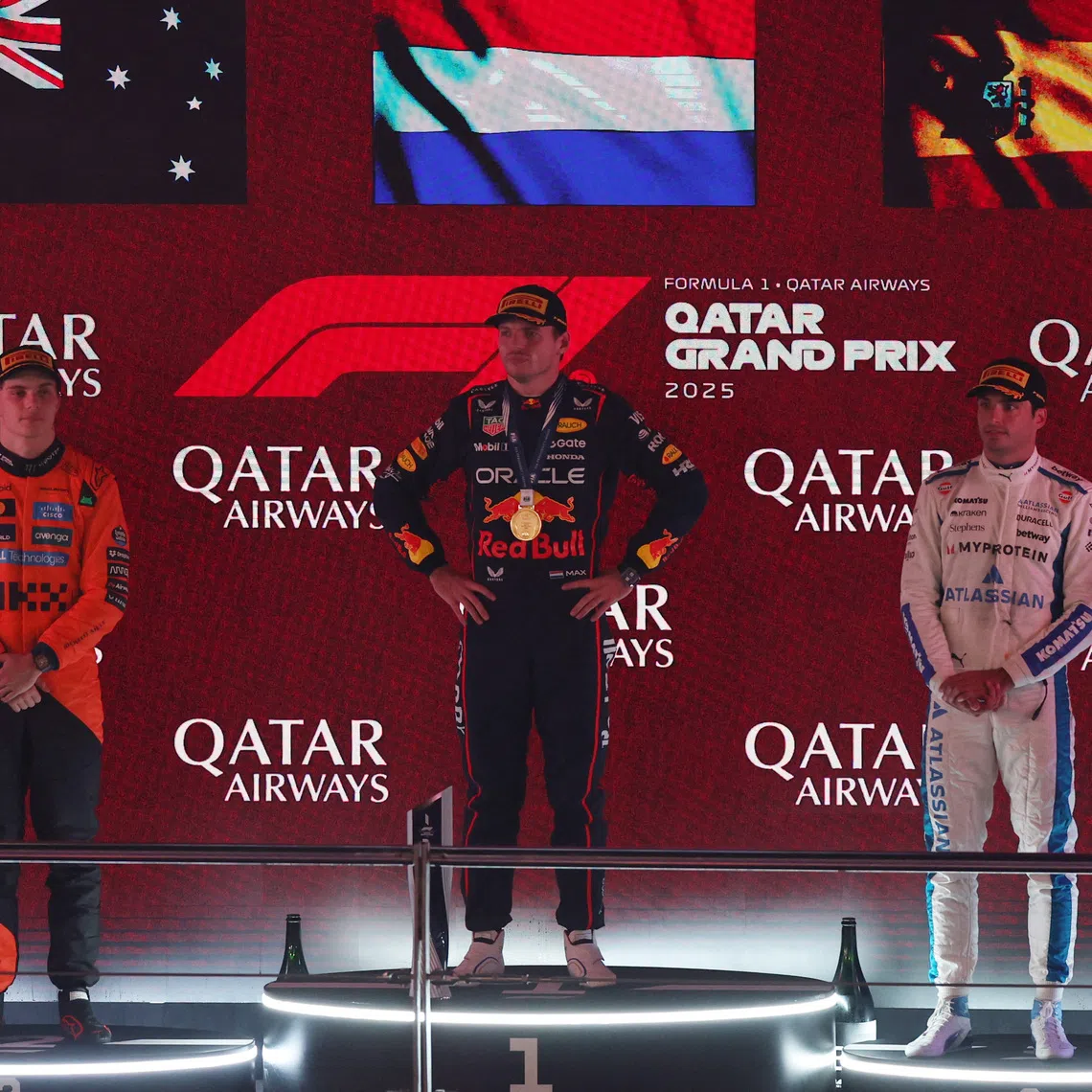 Red Bull’s Max Verstappen (centre) stands on the podium after winning the 2025 Qatar Grand Prix alongside second placed McLaren’s Oscar Piastri and third placed Williams’ Carlos Sainz Jr.