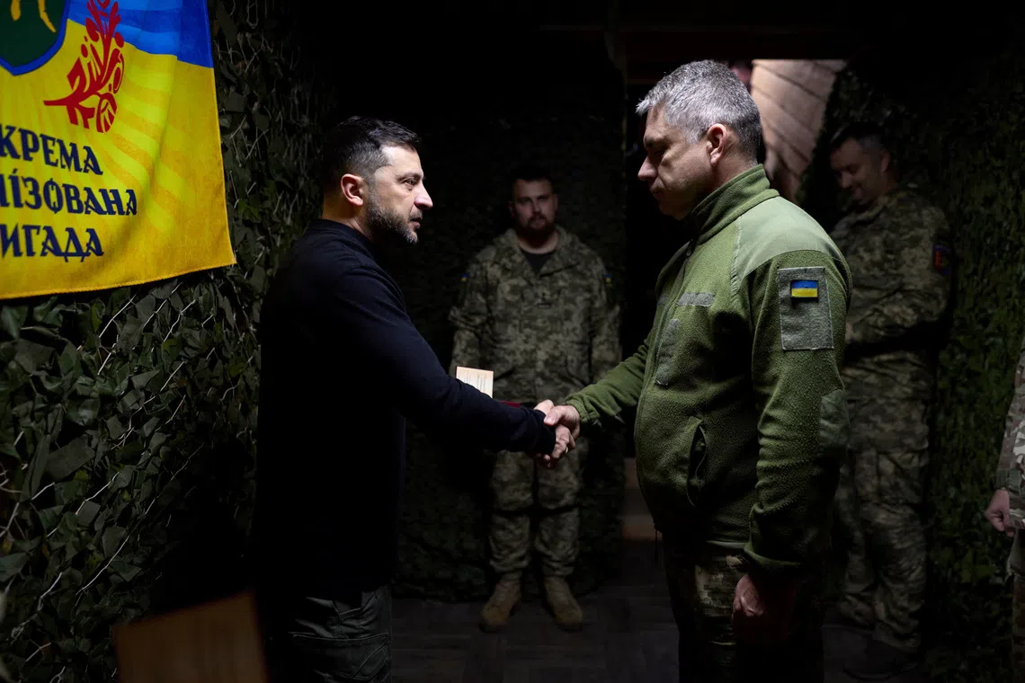 Ukraine's President Volodymyr Zelenskiy awards a Ukrainian serviceman while he visits a command position of the 65th Separate Mechanized Brigade 'Velykyi Luh' at a front line, amid Russia's attack on Ukraine, in Zaporizhzhia region, Ukraine November 13, 2025. Ukrainian Presidential Press Service/Handout via REUTERS