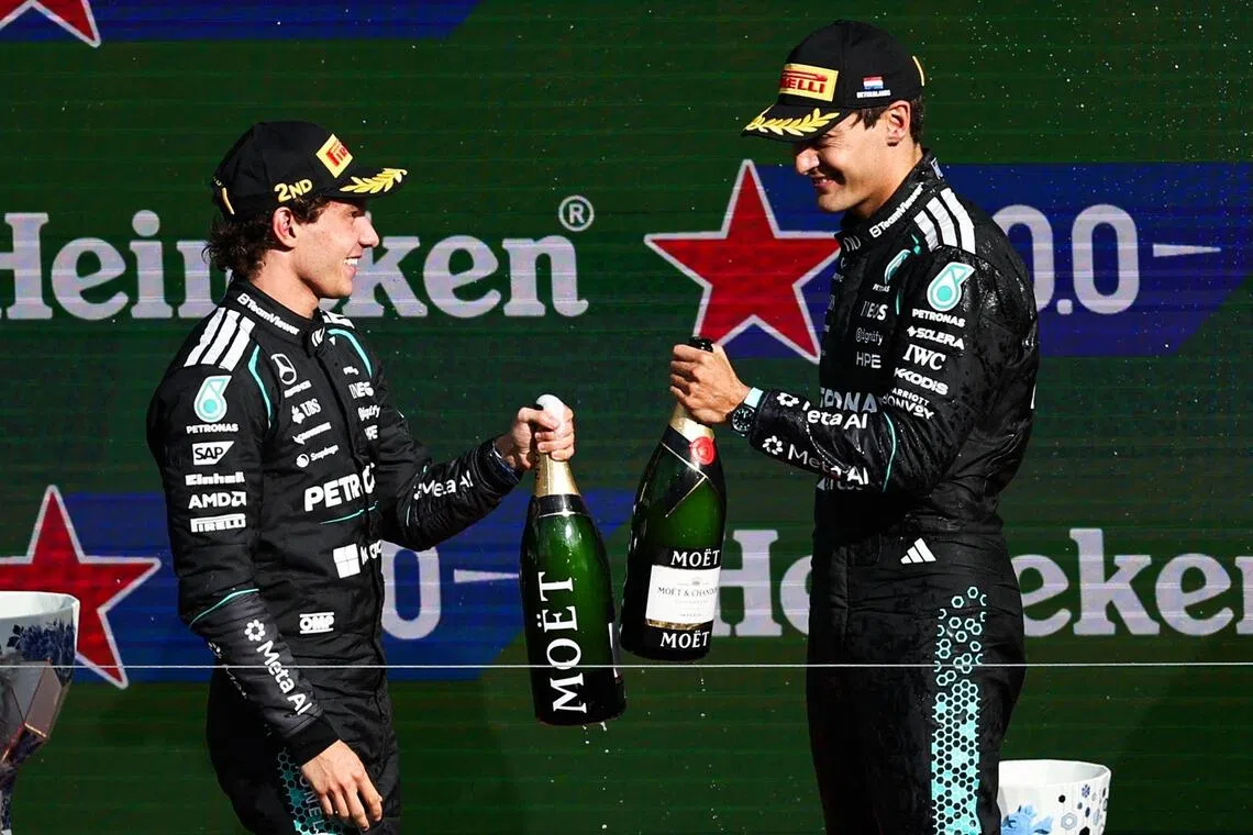 Mercedes drivers Kimi Antonelli (left) and George Russell celebrate on the podium after placing second and third at the Dutch Grand Prix at Zandvoort.