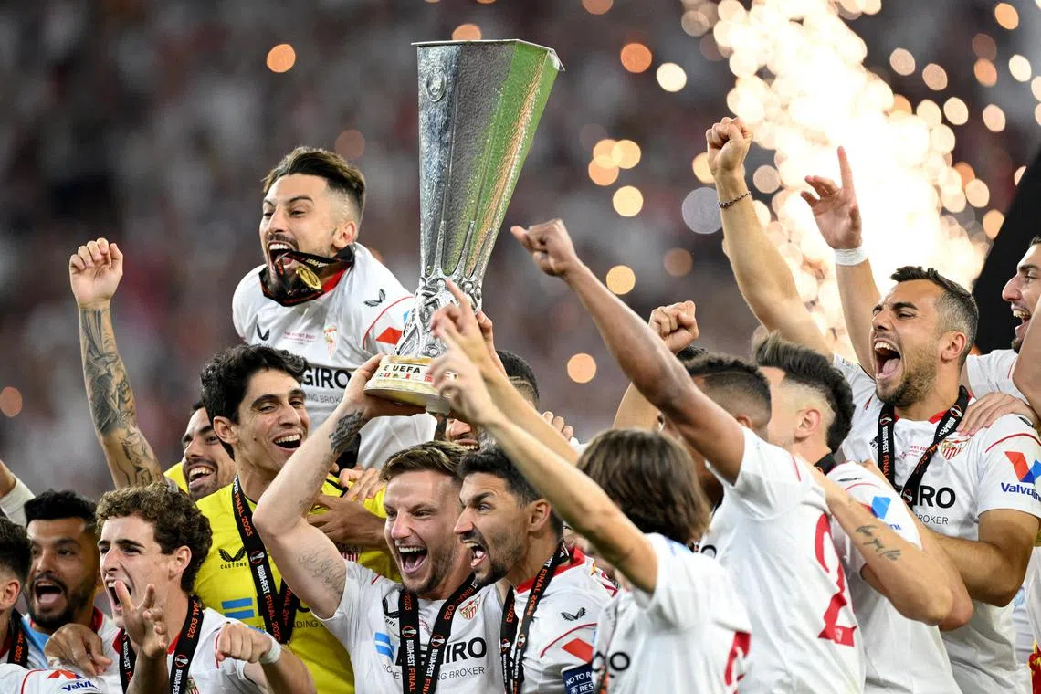 Sevilla's Ivan Rakitic and Jesus Navas lift the trophy as they celebrate winning the Europa League with teammates.