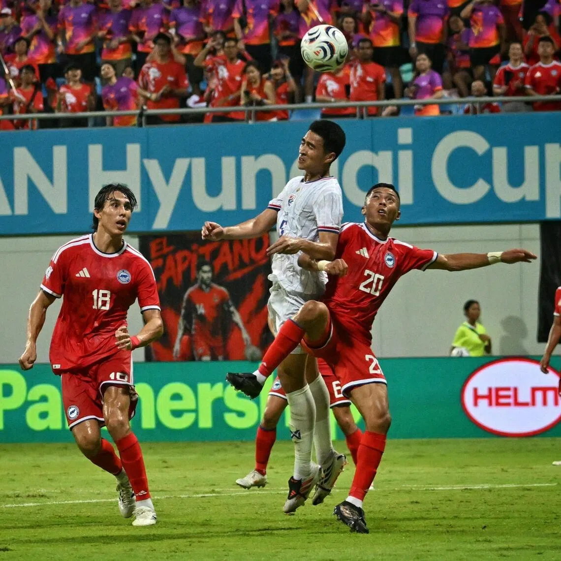Singapore’s Shawal Anuar tussling with a Thai player as Jacob Mahler looks on during the Lions’ 3-1 loss to Thailand in the ASEAN Championship semi-final, first leg on Aug 15.