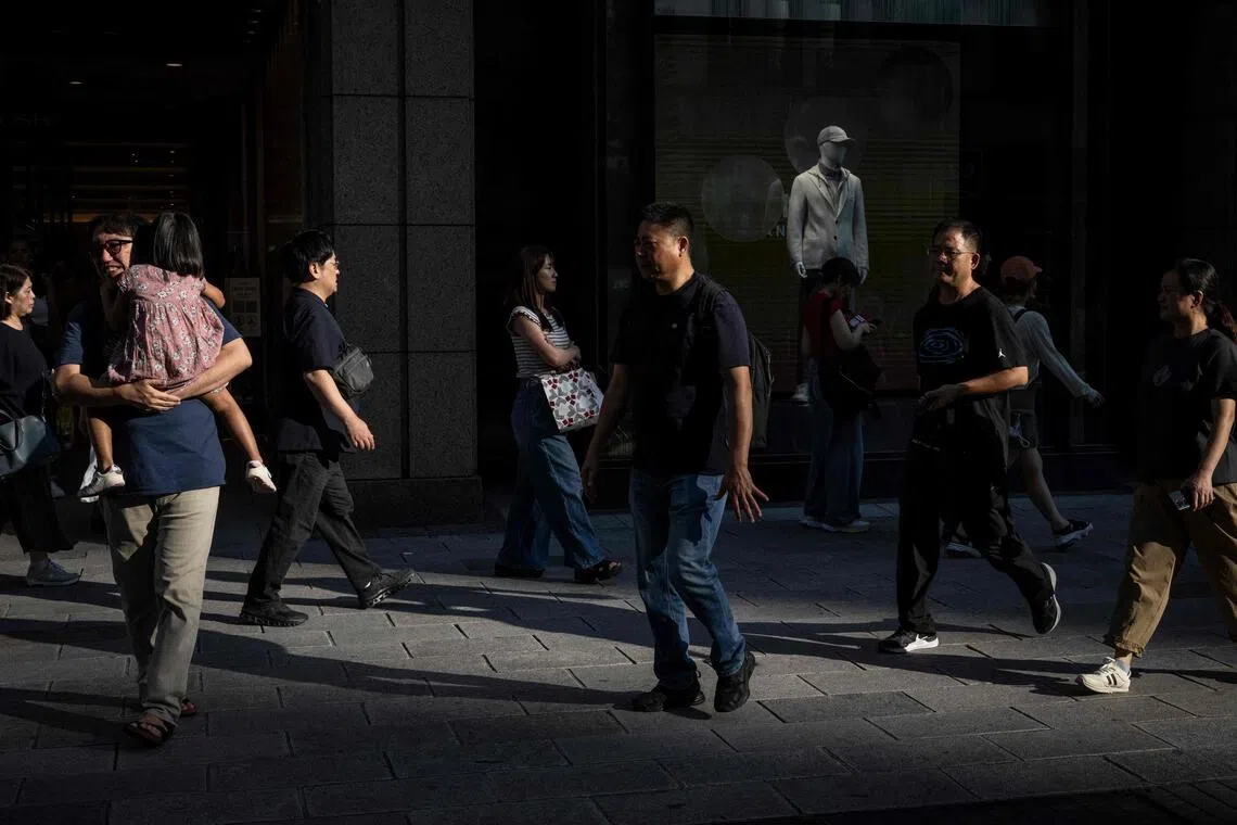 This picture taken on September 6, 2025 shows people walking through the Ginza area in Tokyo. (Photo by Yuichi YAMAZAKI / AFP)