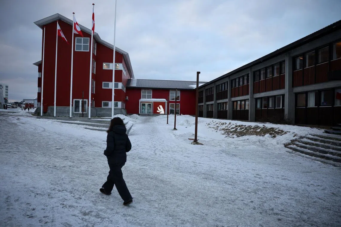 A person walks in front of the parliament in Nuuk, Greenland, February 2, 2026. REUTERS/Stoyan Nenov
