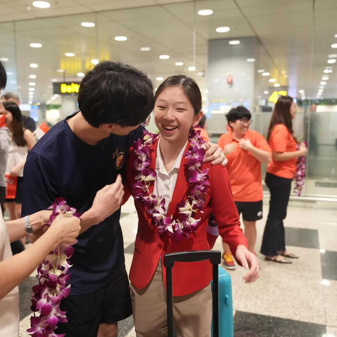 National swimmer Julia Yeo, 14, being welcomed by her family after returning from the Thailand SEA Games on Dec 16, 2025. Yeo won gold for Singapore, alongside teammates Quah Ting Wen, Quah Jing Wen and Letitia Sim.