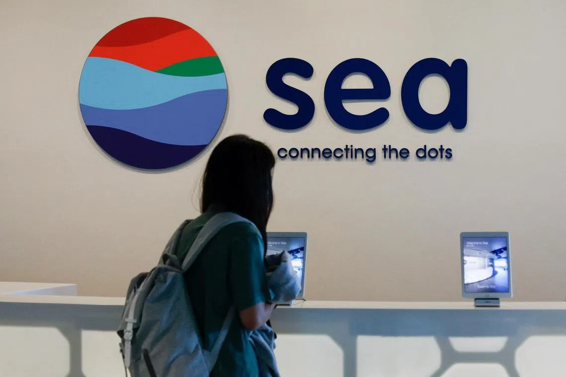 FILE PHOTO: A person stands in front of a signage of Southeast Asian e-commerce and gaming group Sea Ltd's, at their office in Singapore March 5, 2021. REUTERS/Edgar Su/File Photo