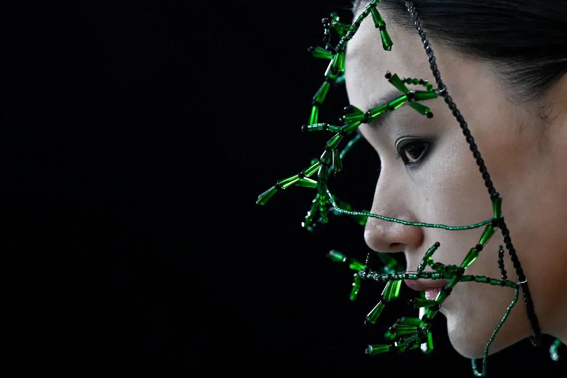 A model prepares backstage before presenting creations during the opening ceremony of China Fashion Week in Beijing on March 24.