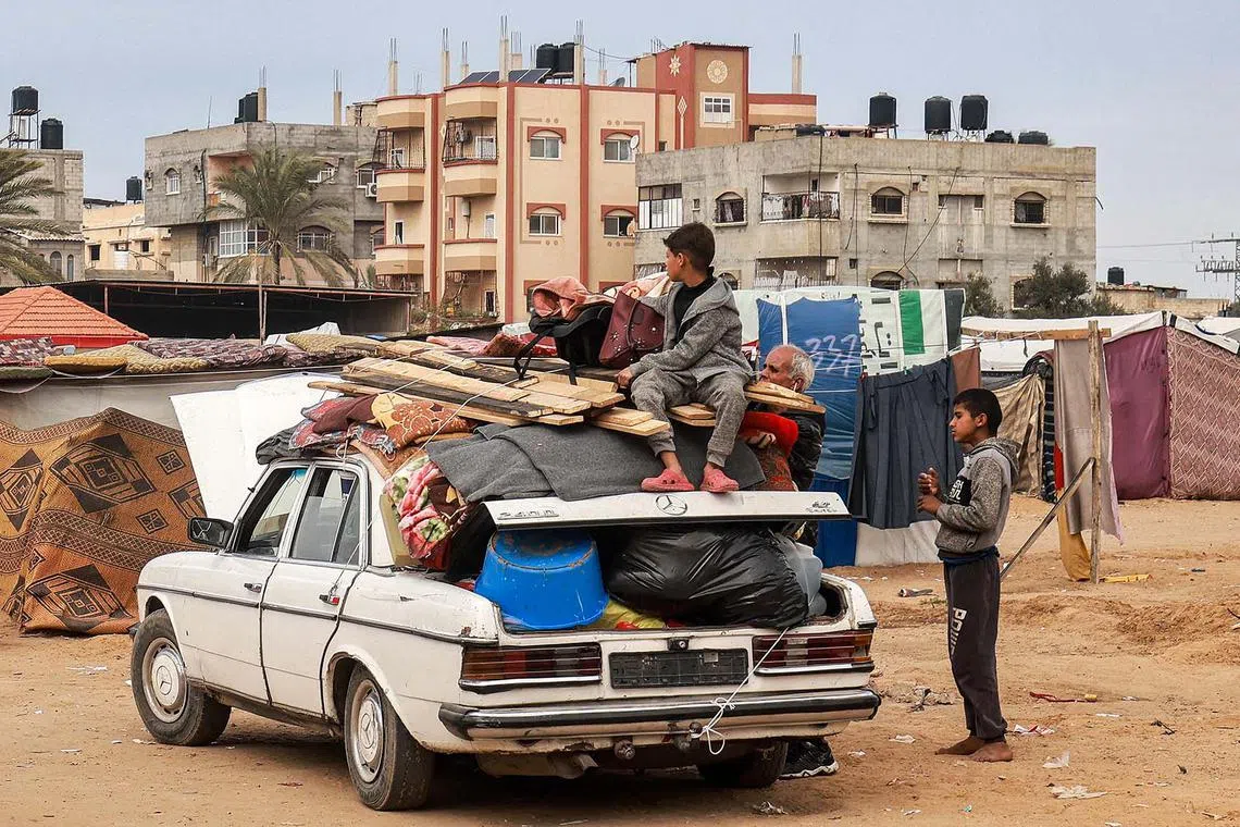 A child sitting atop items secured onto a vehicle by rope as people flee from Rafah in the southern Gaza Strip on Feb 13, 2024 north towards the centre of the Palestinian territory amid the ongoing conflict between Israel and the Palestinian militant group Hamas. 