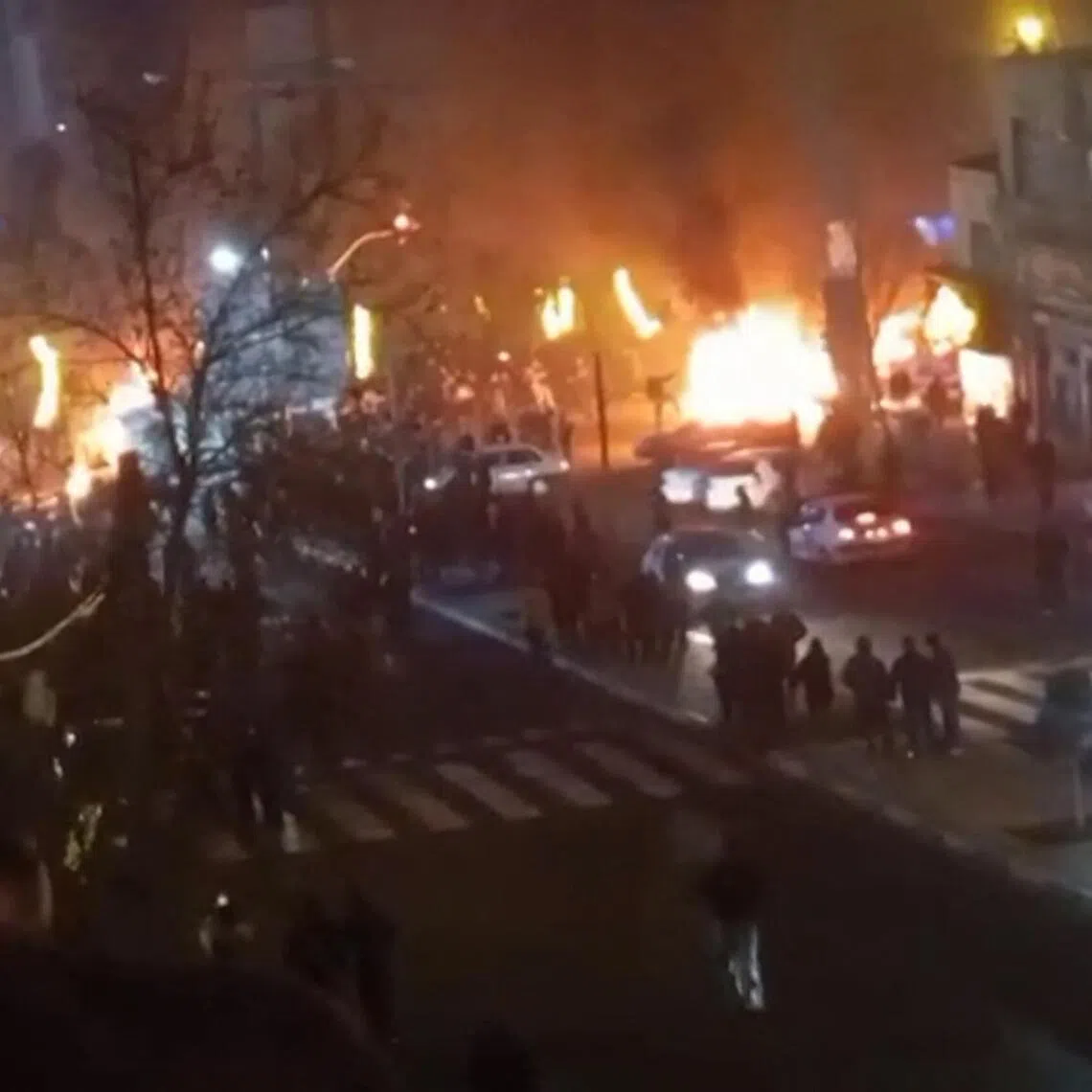 This video grab taken on Jan 14, 2026 from UGC images posted on social media on Jan 9 shows cars set on fire during a protest on Saadat Abad Square in Tehran.  