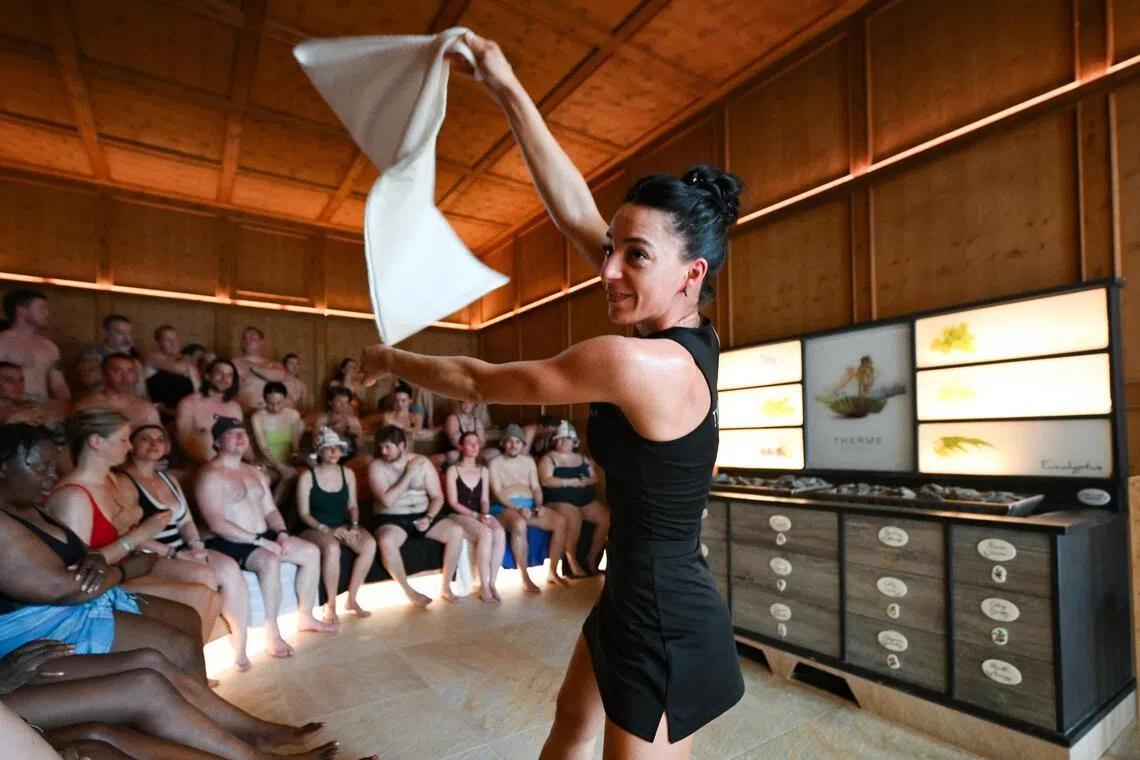 Andreea Brostiuc, 30, an aufgussmeister, performing a ritual called Royal Honey inside the Provence sauna, with temperatures between 75 deg C and 90 deg C.