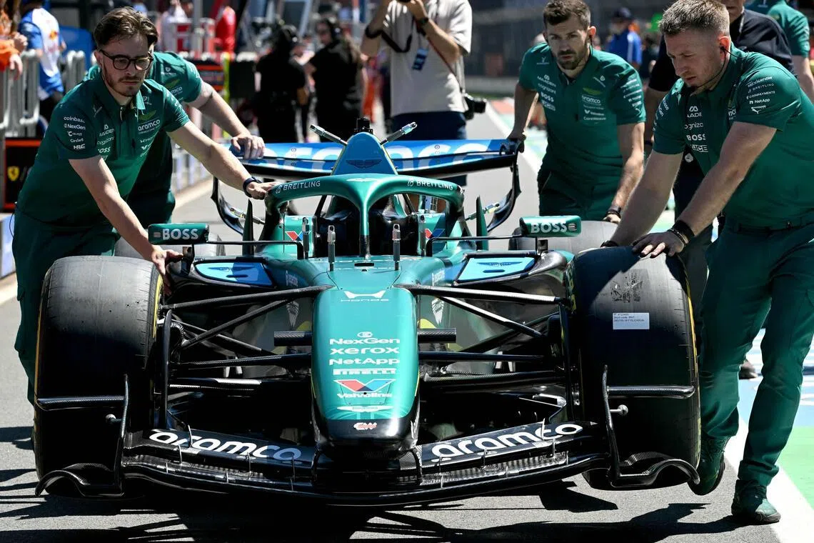 Mechanics take the car of Aston Martin’s Canadian driver Lance Stroll for scrutineering ahead of the Formula One Australian Grand Prix at Melbourne’s Albert Park on March 5, 2026. (Photo by Paul Crock / AFP) / -- IMAGE RESTRICTED TO EDITORIAL USE - STRICTLY NO COMMERCIAL USE --