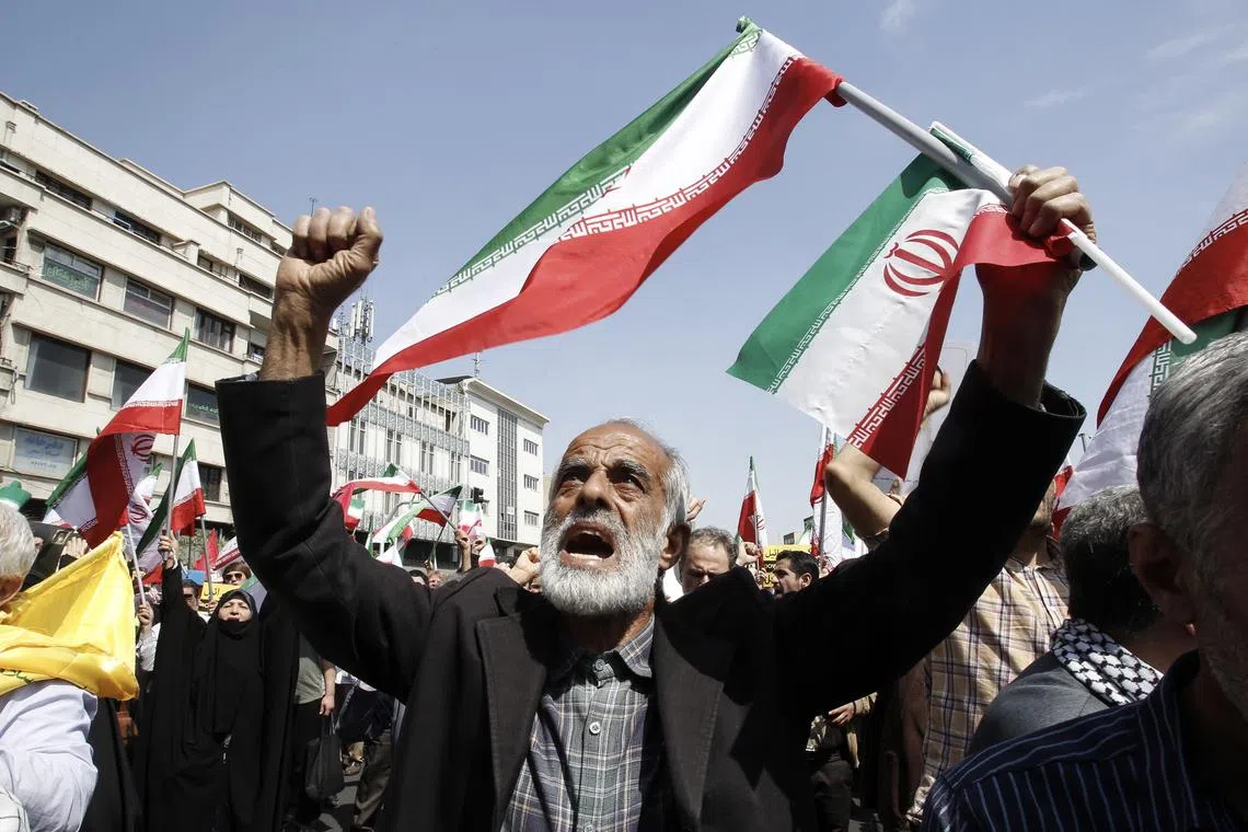 Iranians shout slogans and wave Iranian flags during an anti-Israel rally in Tehran, Iran.
