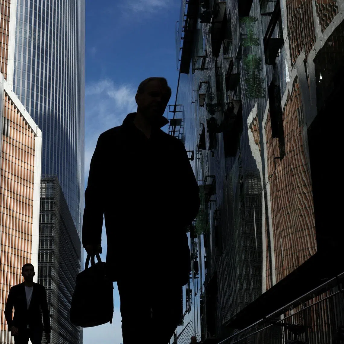 People walk at the foot of skyscrapers of the Moscow International Business Centre, also known as Moskva-City, in Moscow, Russia, October 2, 2025. REUTERS/Ramil Sitdikov