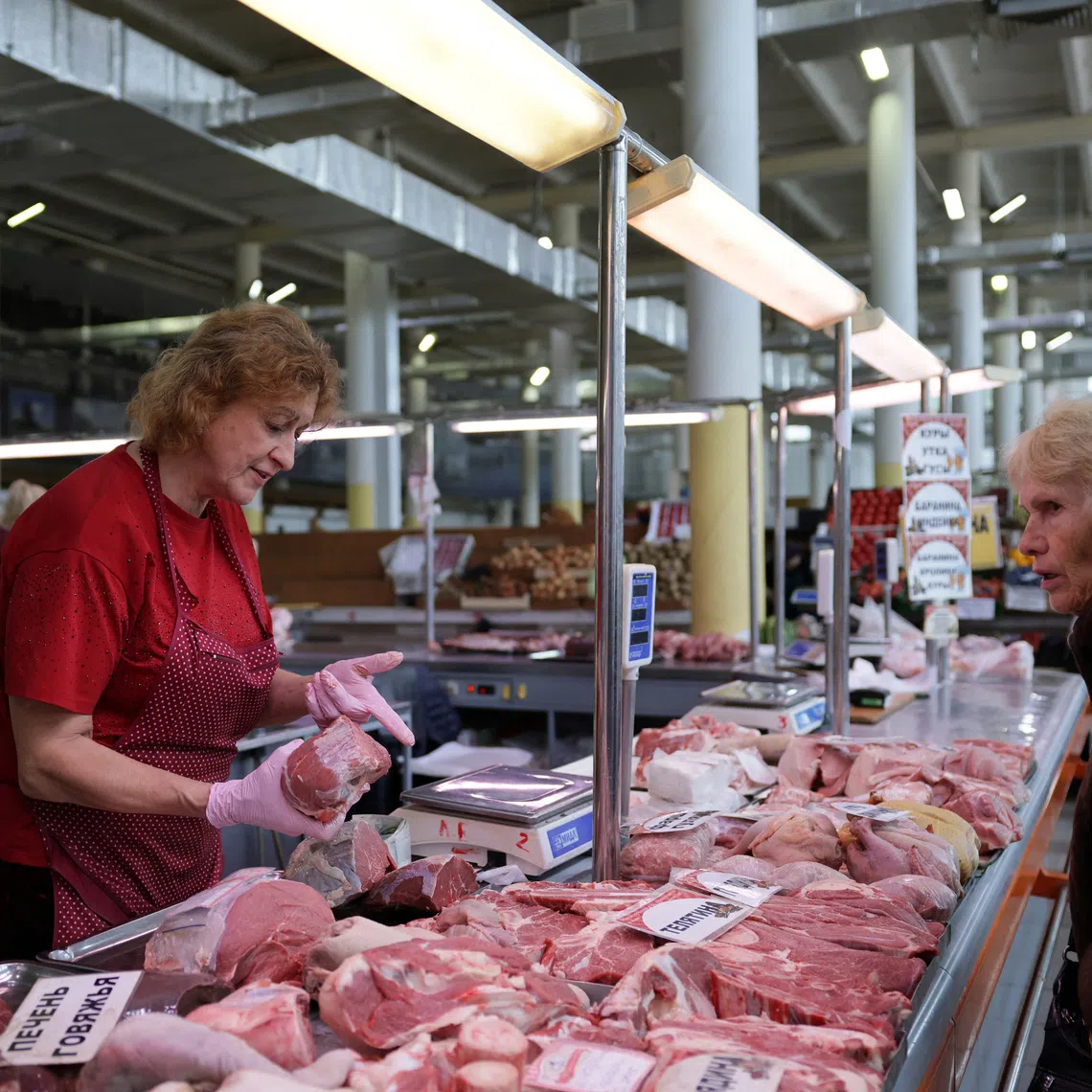 A vendor shows cuts of meat to a customer at a market in Yaroslavl, Russia, September 12, 2026. REUTERS/Anastasia Barashkova