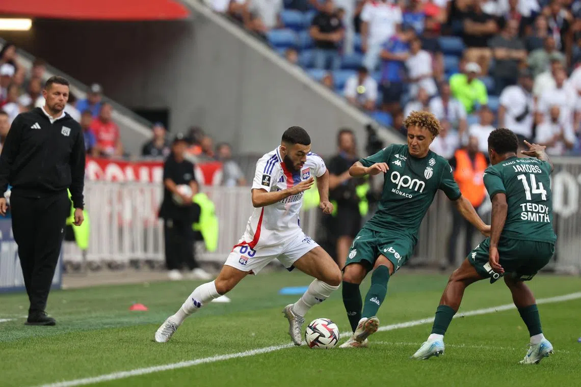 Lyon's Georgian forward Georges Mikautadze (left) fights for the ball with Monaco's French midfielder Maghnes Akliouche in the French Ligue 1 football match at The Groupama Stadium on Aug 24, 2024.