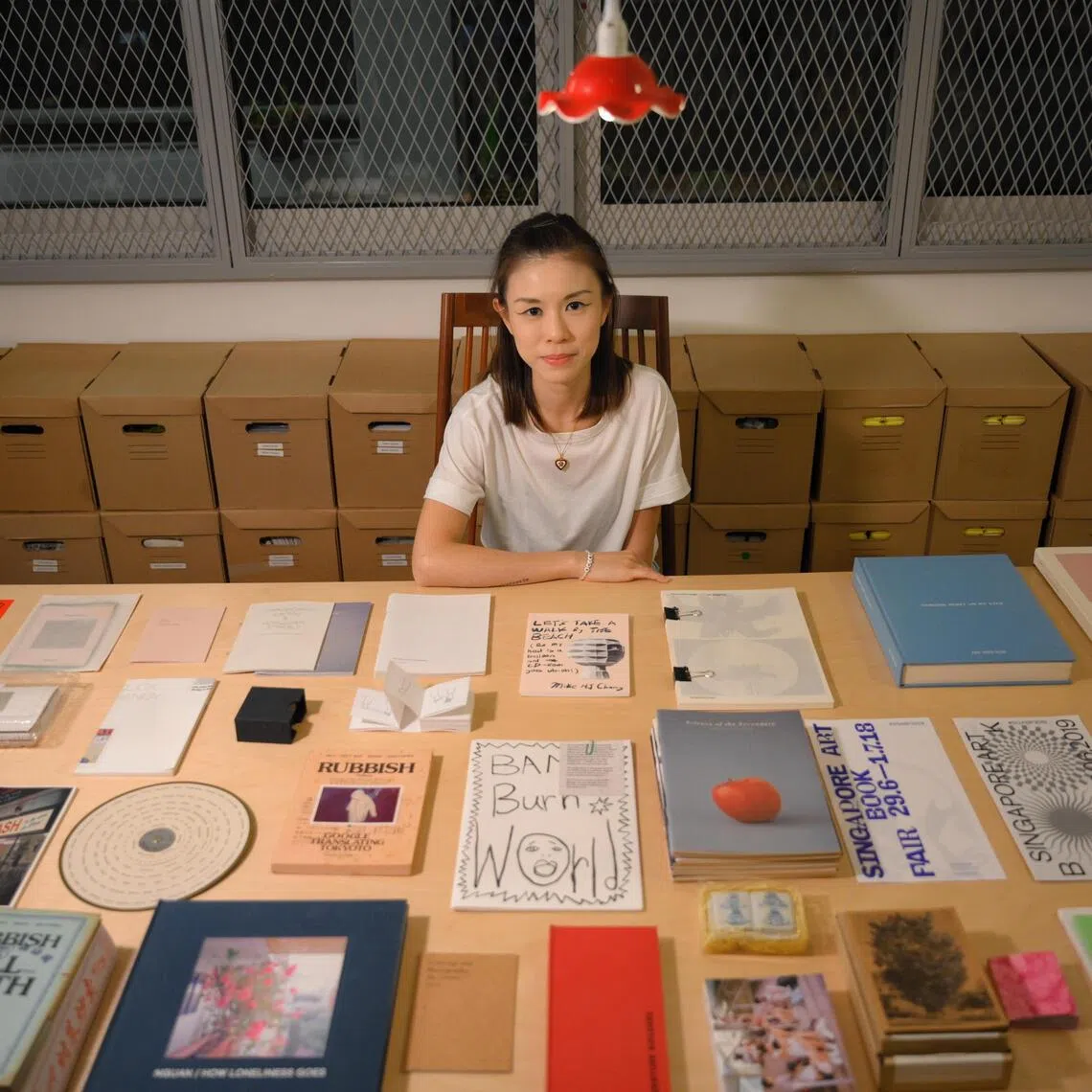 Singapore Art Book Fair founder Renee Ting pictured with some zines and books from the fair over the years. SGABF returns from Oct 31 to Nov 2.
