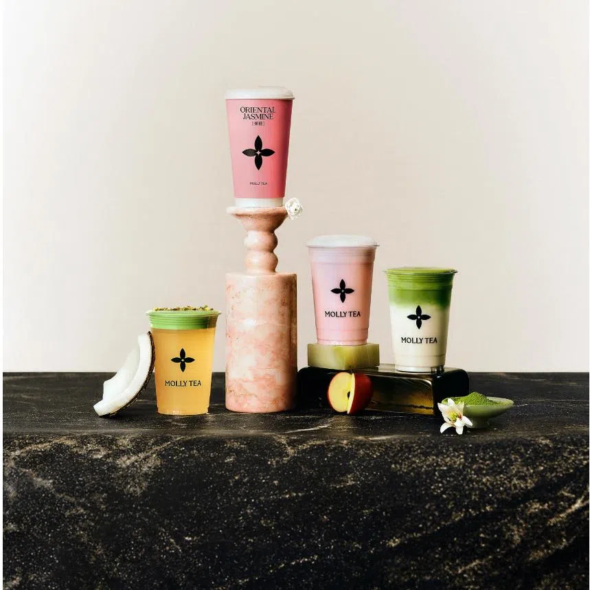 Molly Tea's (left photo, from left to right) Pistachio Jasmine Coconut, Premium Jasmine Milk Tea, Premium Jasmine Apple Milk Tea and White Champaca Matcha; and Molly Tea merchandise (right). 